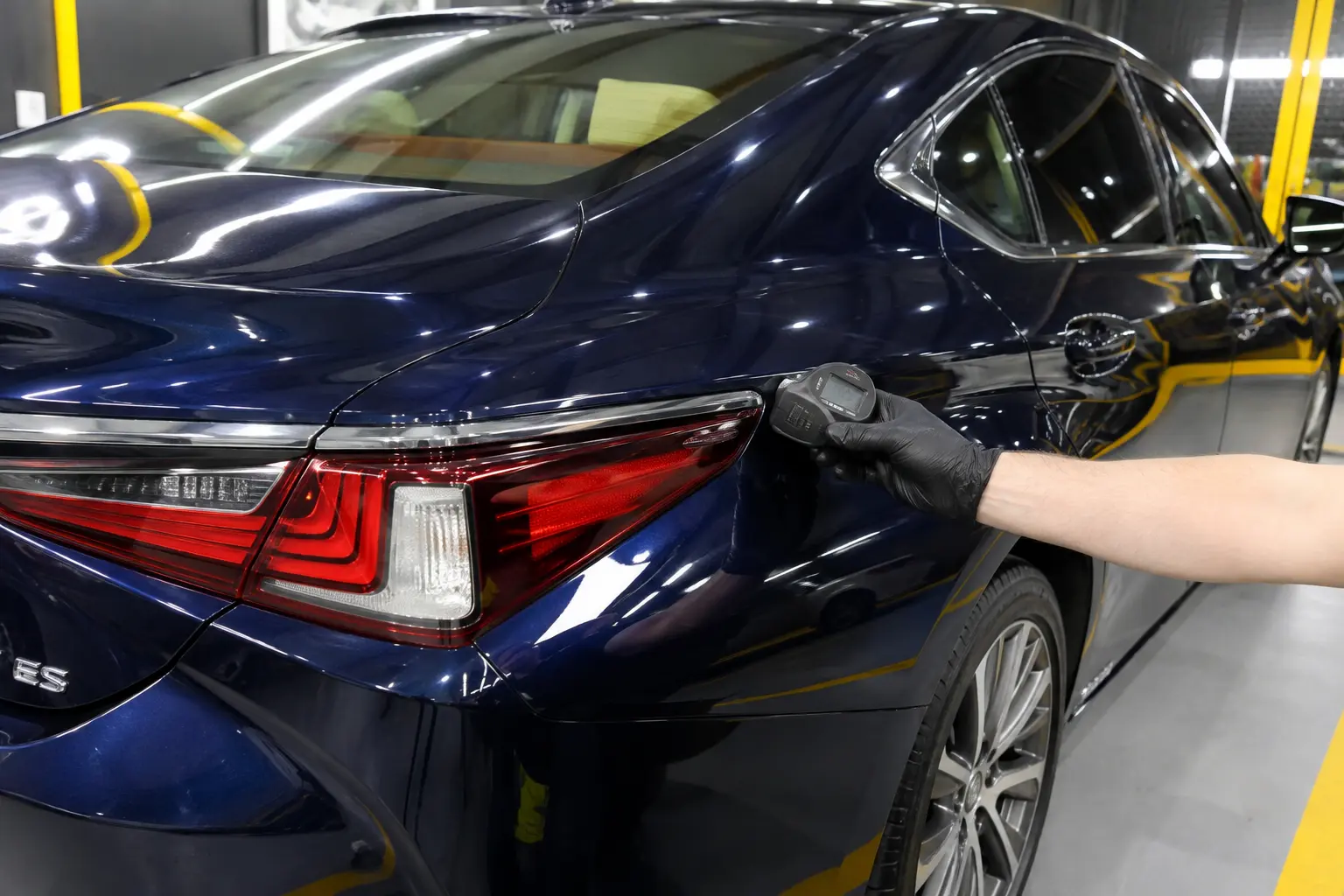 Paint-depth measurement on a blue Lexus body panel during inspection